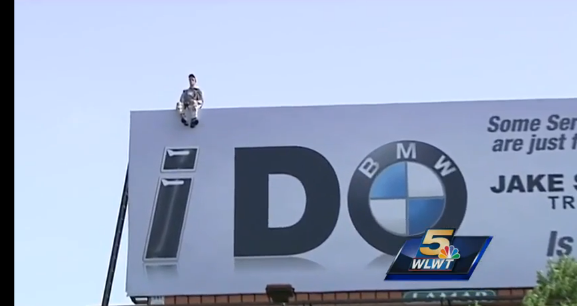 mannequin on top of billboard sign